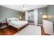 Bedroom with green walls, hardwood floors, and a bed with white comforter at 9021 Winged Thistle Ct, Raleigh, NC 27617