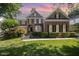 Beautiful brick home with a manicured lawn and mature landscaping under a colorful sky at 9021 Winged Thistle Ct, Raleigh, NC 27617