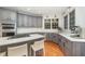 Modern kitchen featuring gray cabinets, stainless steel appliances, white countertops, and a center island with bar stools at 9021 Winged Thistle Ct, Raleigh, NC 27617