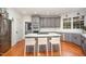 Well-lit kitchen with gray cabinets, stainless steel appliances, and a center island with bar seating at 9021 Winged Thistle Ct, Raleigh, NC 27617
