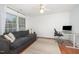 Living room with gray couch, modern desk, and sunlit windows at 9021 Winged Thistle Ct, Raleigh, NC 27617