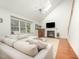 Bright living room with fireplace, vaulted ceiling, hardwood floors, and a comfortable L-shaped sofa at 9021 Winged Thistle Ct, Raleigh, NC 27617