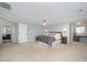 Large main bedroom with carpeting, large bed, and en suite bathroom and extra sitting area at 9021 Winged Thistle Ct, Raleigh, NC 27617