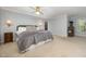 Serene main bedroom with a large bed, soft carpeting, and sconce lighting creating a relaxing atmosphere at 9021 Winged Thistle Ct, Raleigh, NC 27617