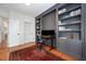 This office features custom built-ins, dual monitors, wood flooring, and a decorative red rug at 9021 Winged Thistle Ct, Raleigh, NC 27617