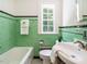Vintage green tiled bathroom with black accents, tub, and sink at 907 W Johnson St, Raleigh, NC 27605