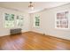 Large bedroom with hardwood floors and an abundance of windows at 907 W Johnson St, Raleigh, NC 27605