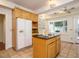 Eat-in kitchen with center island, white refrigerator, and bright bay window at 907 W Johnson St, Raleigh, NC 27605