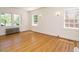 Bright living room with hardwood floors, radiator, and multiple windows for sunlight at 907 W Johnson St, Raleigh, NC 27605