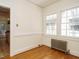 Bright sunroom with hardwood floors, radiator, and double-hung windows offering natural light at 907 W Johnson St, Raleigh, NC 27605