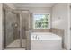 Bathroom featuring a glass door shower, bathtub and window at 915 Chapanoke Rd, Raleigh, NC 27603
