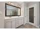 Bathroom featuring double sink vanity, large mirror, and glass doored shower at 915 Chapanoke Rd, Raleigh, NC 27603