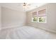 Neutral bedroom with carpeted floors, ceiling fan and two windows with blinds at 915 Chapanoke Rd, Raleigh, NC 27603