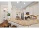 Open kitchen has granite counters with breakfast bar seating, stainless appliances, and hardwood floors at 915 Chapanoke Rd, Raleigh, NC 27603