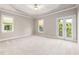 Large main bedroom with carpet, ceiling fan, tray ceiling, windows and french doors at 915 Chapanoke Rd, Raleigh, NC 27603