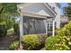 View of a screened-in porch surrounded by lush landscaping and manicured shrubs at 915 Chapanoke Rd, Raleigh, NC 27603