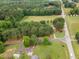 Aerial view of a property with tree cover, expansive lawns, and surrounding woods at 100 Martindale Dr, Youngsville, NC 27596