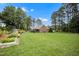 Spacious backyard with well-maintained lawn, garden plots and mature trees at 100 Martindale Dr, Youngsville, NC 27596