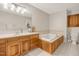 Well-lit bathroom with a large vanity, soaking tub, and tiled floors at 100 Martindale Dr, Youngsville, NC 27596