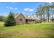 Beautiful brick home with a charming front porch and dormer windows surrounded by lush greenery at 100 Martindale Dr, Youngsville, NC 27596