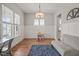 Bright dining room with hardwood floors, wainscoting, and modern light fixture at 1006 Whistler St, Durham, NC 27713