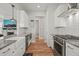 Well-lit kitchen with white cabinets, granite countertops, and stainless steel appliances at 1006 Whistler St, Durham, NC 27713
