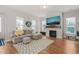 Bright living room features a cozy fireplace, hardwood floors, and comfortable sectional sofa with accent pillows at 1006 Whistler St, Durham, NC 27713