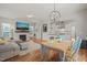 Open-concept living room features a fireplace, TV, modern lighting, and hardwood floors leading to the kitchen at 1006 Whistler St, Durham, NC 27713
