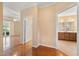 Hallway with hardwood floors leading to a well-lit bathroom and sitting area with a fan at 102 Mikaila Dr, Gibsonville, NC 27249