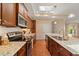 Modern kitchen featuring stainless steel appliances, wooden cabinetry, granite countertops, and hardwood floors at 102 Mikaila Dr, Gibsonville, NC 27249