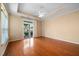Bright main bedroom with tray ceiling, hardwood floors, and a sliding door to the backyard at 102 Mikaila Dr, Gibsonville, NC 27249