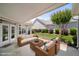 Covered patio with wicker seating, lush backyard, and manicured landscaping at 102 Mikaila Dr, Gibsonville, NC 27249