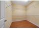 Spacious walk-in closet featuring custom shelving, hardwood floors, and ample storage space at 102 Mikaila Dr, Gibsonville, NC 27249