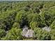 Aerial view of the home nestled among dense trees in a serene, verdant neighborhood at 1105 Tazwell Pl, Raleigh, NC 27612