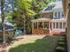 Expansive backyard view with a covered porch, brick patio, and lush green lawn at 1105 Tazwell Pl, Raleigh, NC 27612