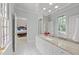 Bathroom with light blue walls, marble countertop, white vanity, and an elegant doorway at 1105 Tazwell Pl, Raleigh, NC 27612