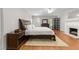 Cozy bedroom featuring hardwood floors, a ceiling fan, fireplace, and a decorative rug under the bed at 1105 Tazwell Pl, Raleigh, NC 27612