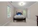 Serene bedroom with soft carpet, neutral walls and two large bright windows at 1105 Tazwell Pl, Raleigh, NC 27612