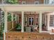 Charming covered patio with brick flooring, ample seating, and a ceiling fan at 1105 Tazwell Pl, Raleigh, NC 27612
