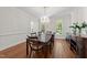Bright dining room with hardwood floors, chandelier, and large windows offers an elegant space for entertaining at 1105 Tazwell Pl, Raleigh, NC 27612