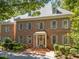 Elegant brick home with dormer windows, gray shutters, and a covered entrance exudes timeless charm and sophistication at 1105 Tazwell Pl, Raleigh, NC 27612