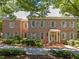 Stately brick home with gray shutters, lush landscaping, and a welcoming brick entryway offers classic curb appeal at 1105 Tazwell Pl, Raleigh, NC 27612