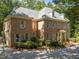Stately brick home featuring mature landscaping, a circular driveway, and a classic architectural design at 1105 Tazwell Pl, Raleigh, NC 27612
