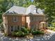 Stately brick home with manicured landscaping and a circular driveway, offering timeless curb appeal at 1105 Tazwell Pl, Raleigh, NC 27612