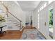 Inviting foyer with hardwood floors, elegant staircase, and a view into the living room exudes classic charm at 1105 Tazwell Pl, Raleigh, NC 27612