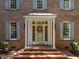 Charming brick home featuring an inviting front door with wreath, surrounded by classic shutters at 1105 Tazwell Pl, Raleigh, NC 27612