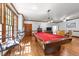 Spacious game room featuring a red felt pool table, wood floors, and large windows with natural light at 1105 Tazwell Pl, Raleigh, NC 27612