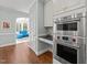 Modern stainless steel oven and microwave with a view into an adjacent living room at 1105 Tazwell Pl, Raleigh, NC 27612