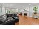 Spacious living room with a black leather couch, fireplace, and hardwood floors at 1105 Tazwell Pl, Raleigh, NC 27612