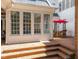 The patio features brick steps and an outdoor seating area with an umbrella for shade at 1105 Tazwell Pl, Raleigh, NC 27612